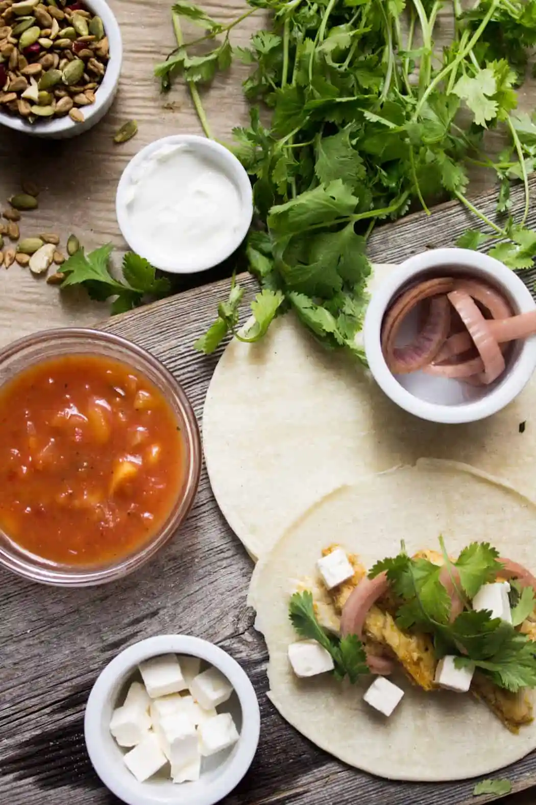 Pink fish tacos with bright, vinegary pickled onions and creamy feta or purple cabbage slaw, and crunchy, sweet salad topper.