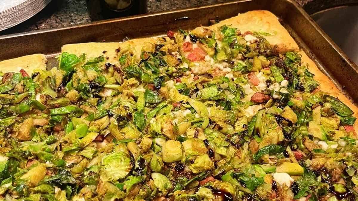 A pizza with brussels sprouts on it.
