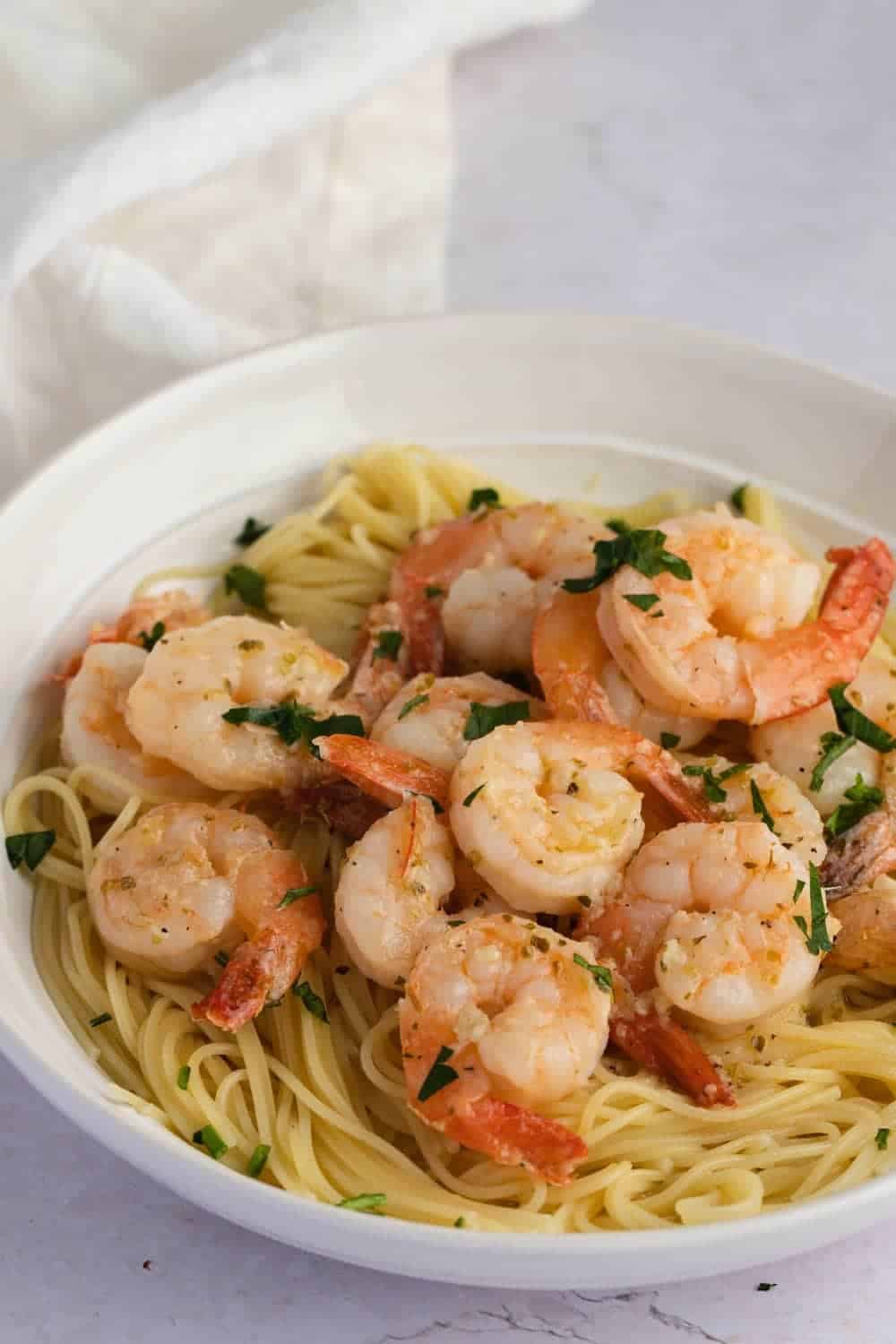 Buttery and Tender Red Lobster Shrimp Scampi with Pasta Served on a White Plate, Garnished with Chopped Parsley.

