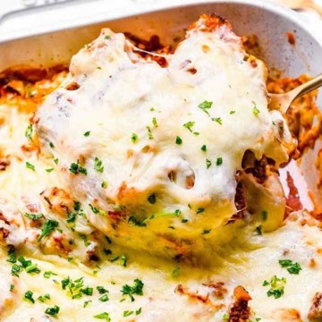 Lasagna in a white baking dish with a fork.