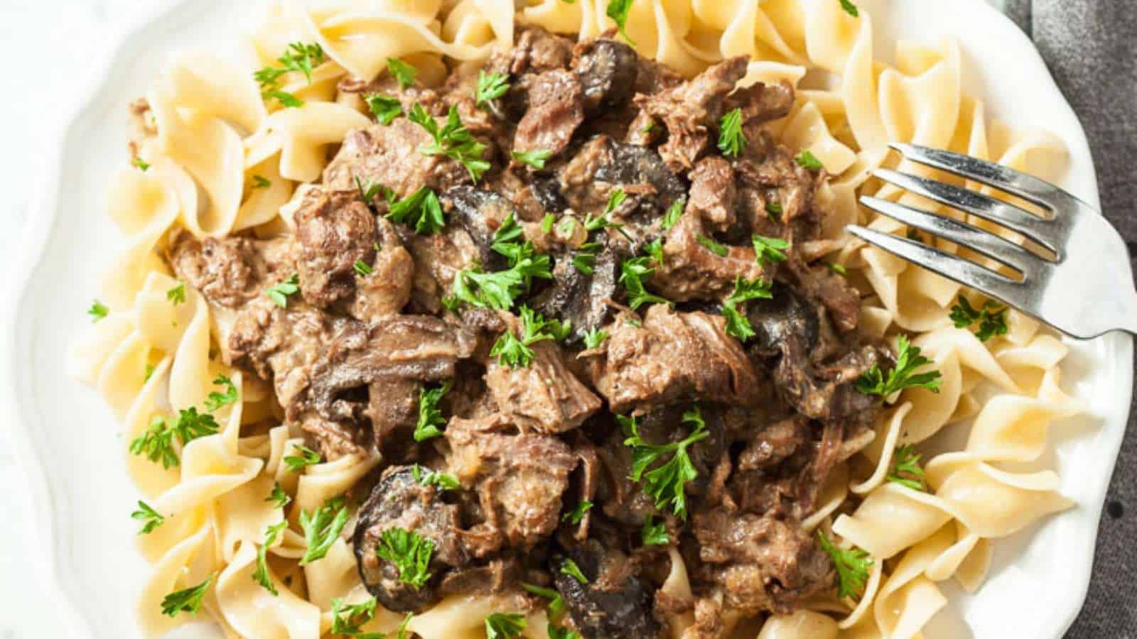 Beef stroganoff with pasta on a plate with a fork.