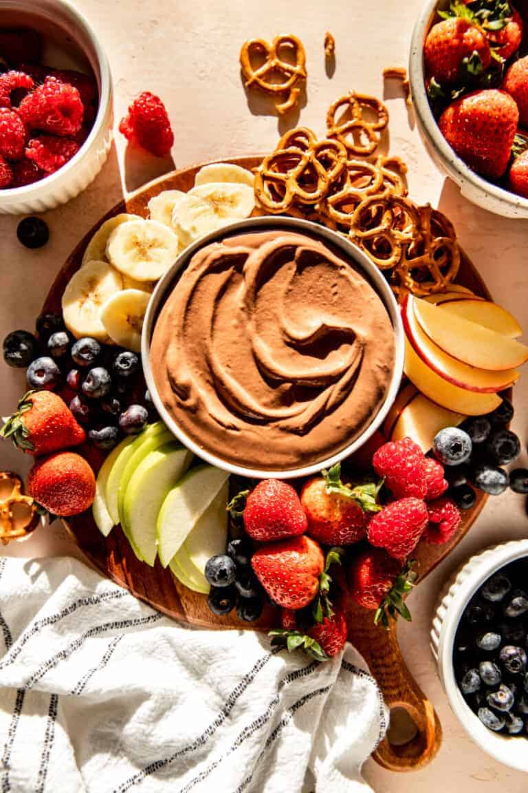 A platter of protein-packed fruit, pretzels, and chocolate dipped pretzels.