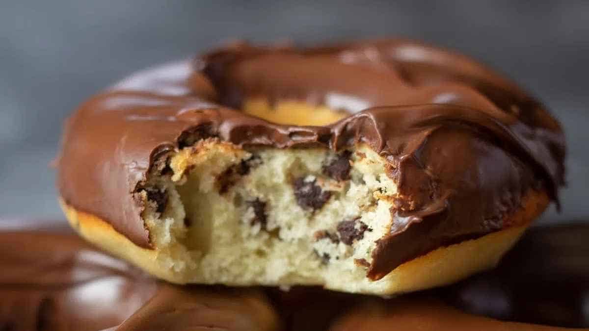 Chocolate chip donuts with a bite taken out of them.