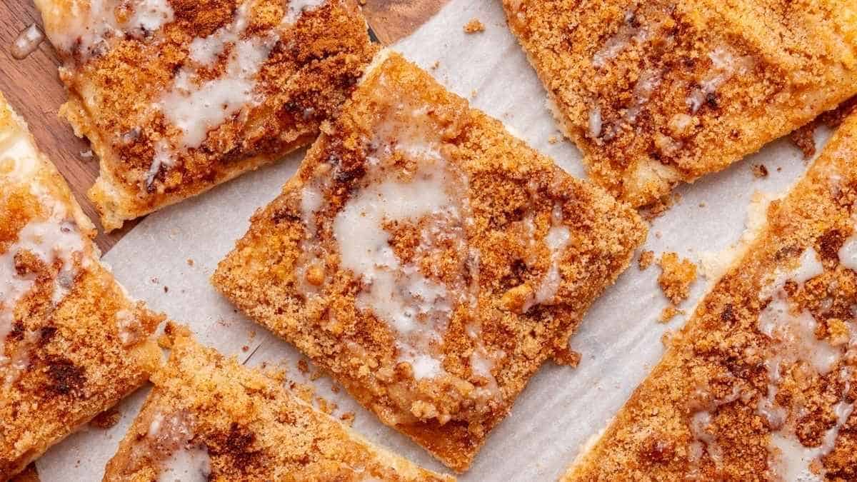 Cinnamon squares with icing on a cutting board.