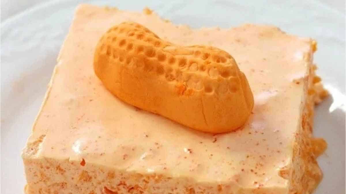 A piece of cake with a peanut on top.