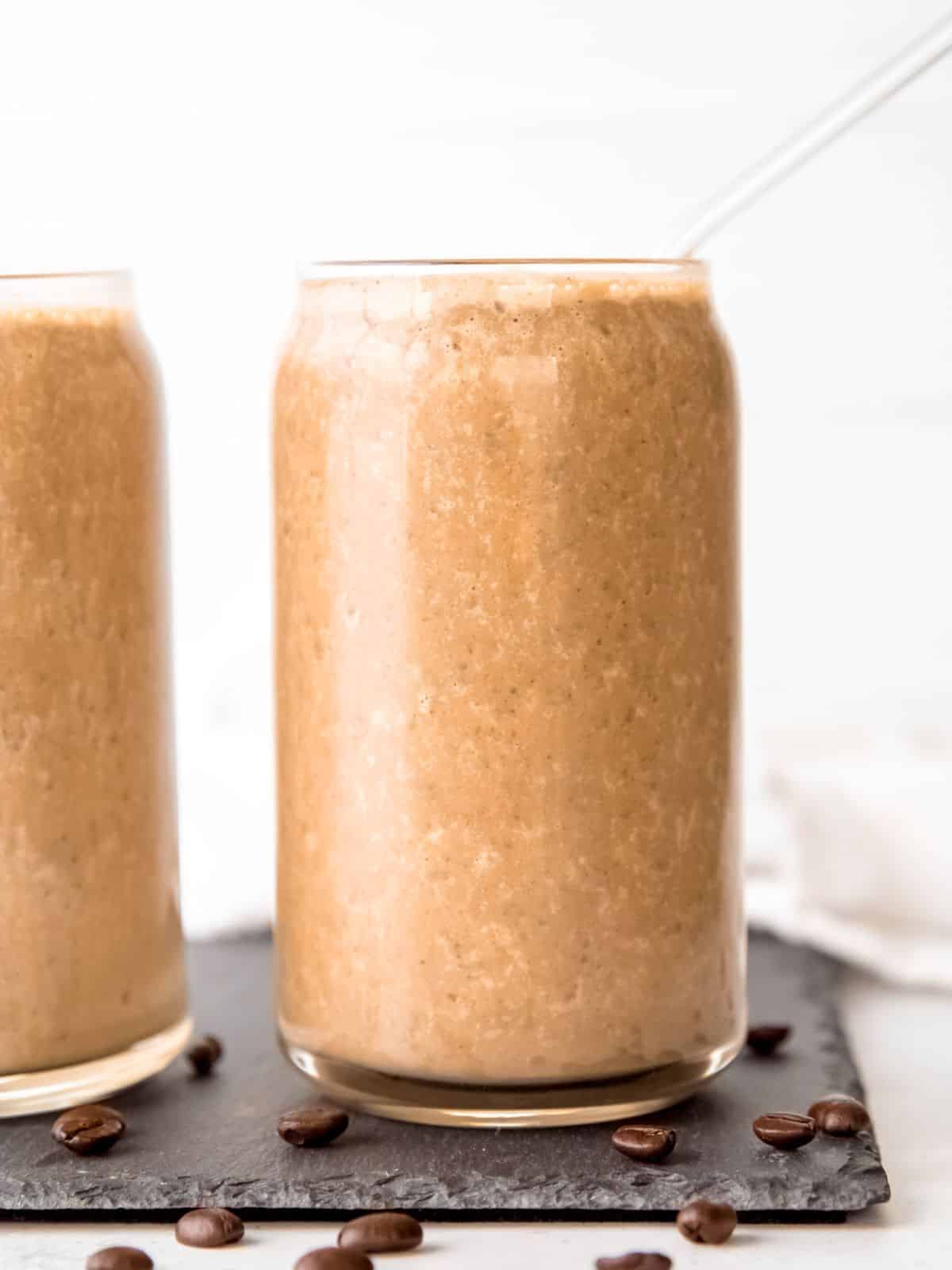 Iced coffee protein shake with chia seeds in a clear glass. 
