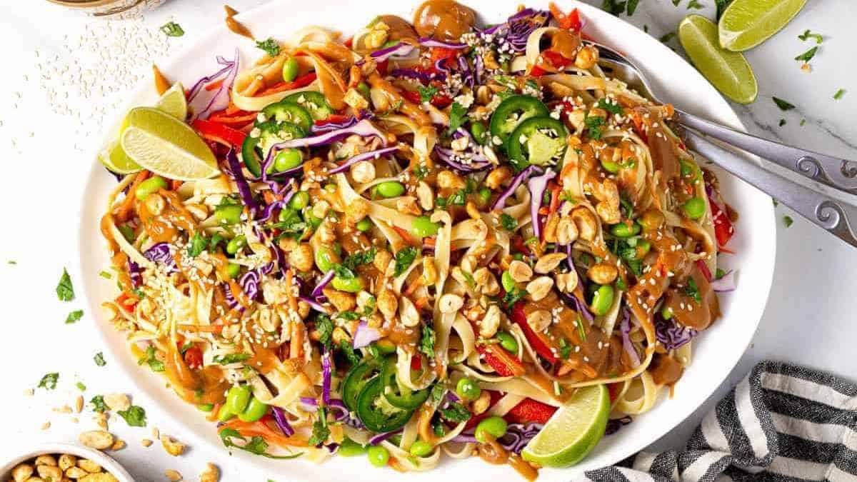 A plate of asian noodle salad with peanuts and vegetables.