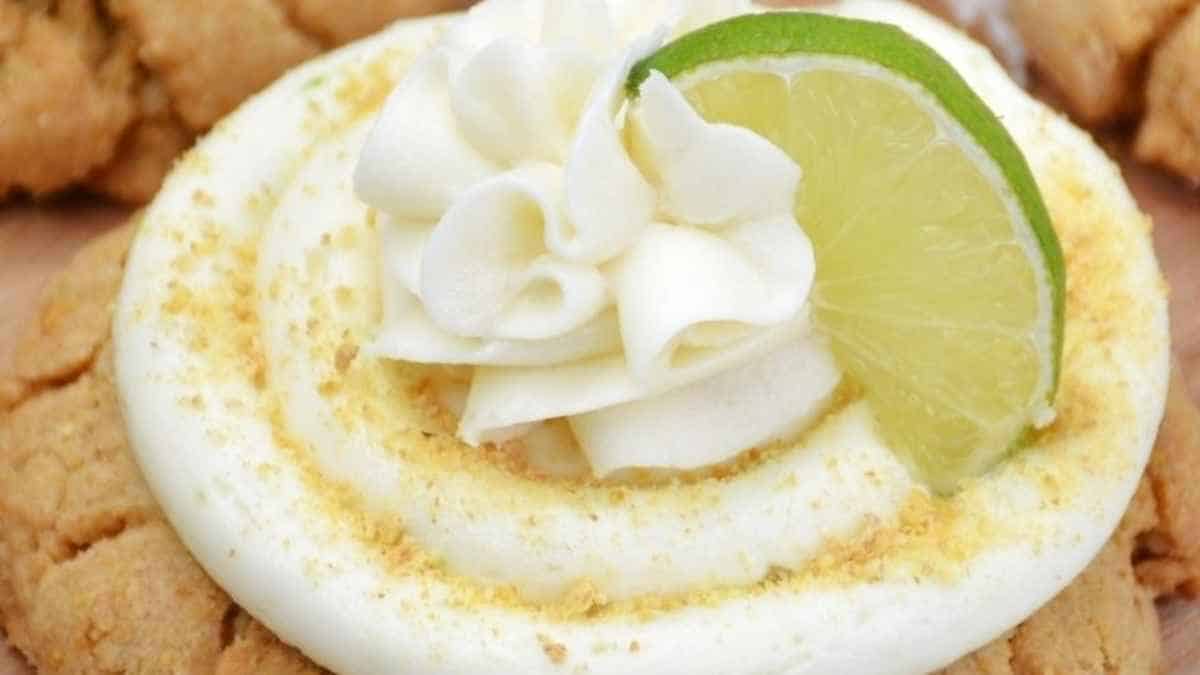A cookie topped with whipped cream and a lime slice.