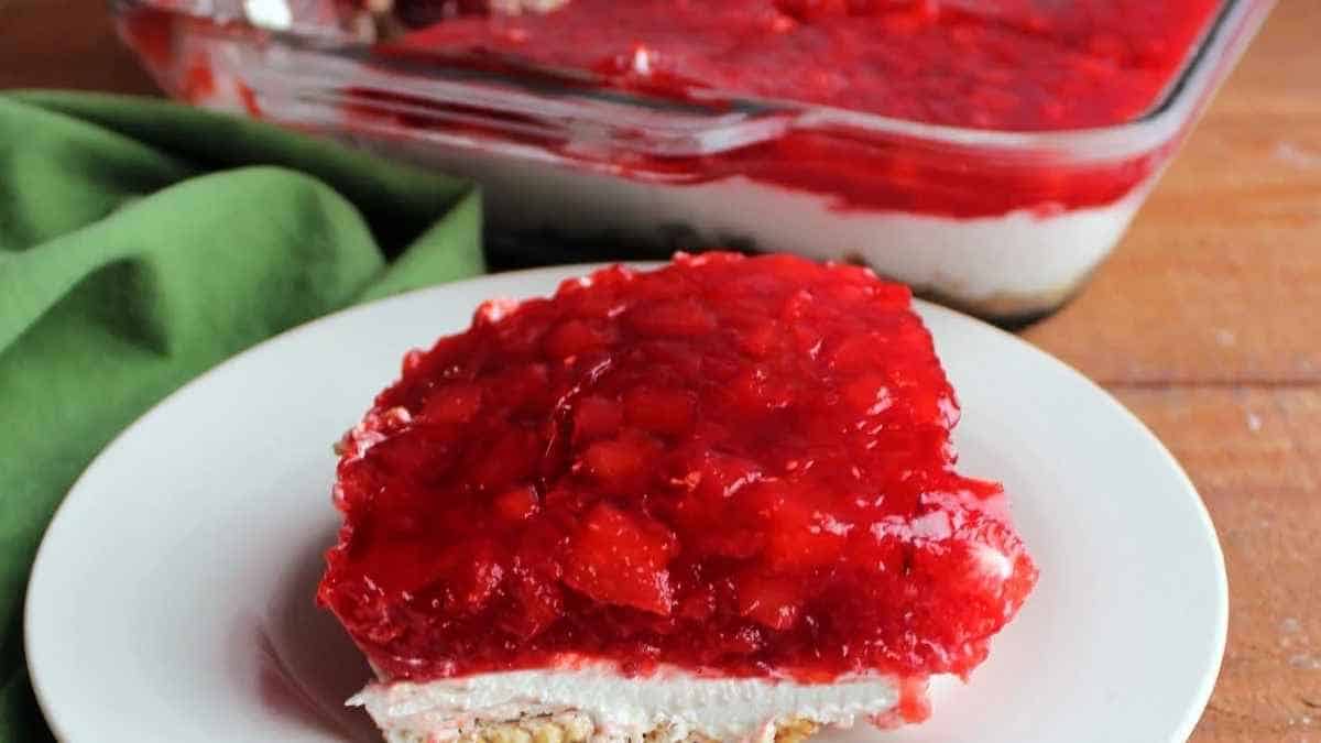 A slice of strawberry cheesecake on a plate.