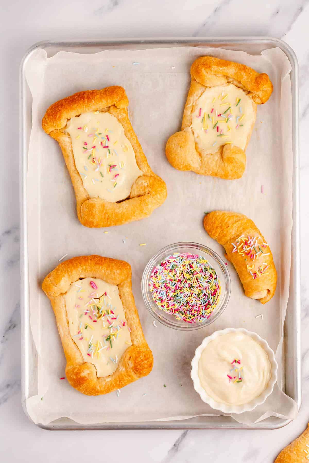 crescent roll cream cheese danishes on a cookie sheet.
