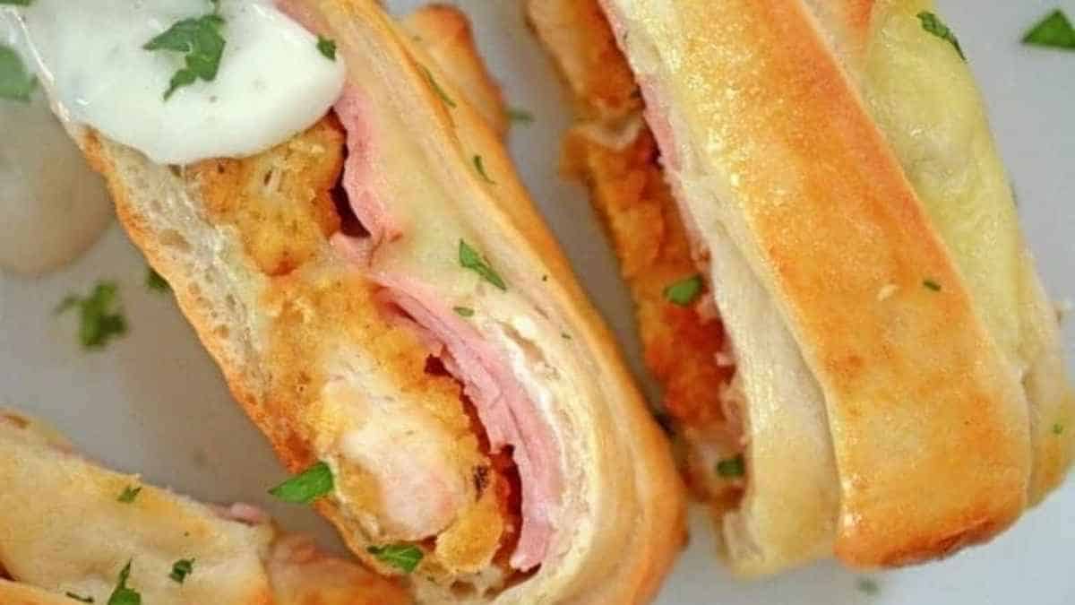 Two sandwiches with ham and cheese on a plate.