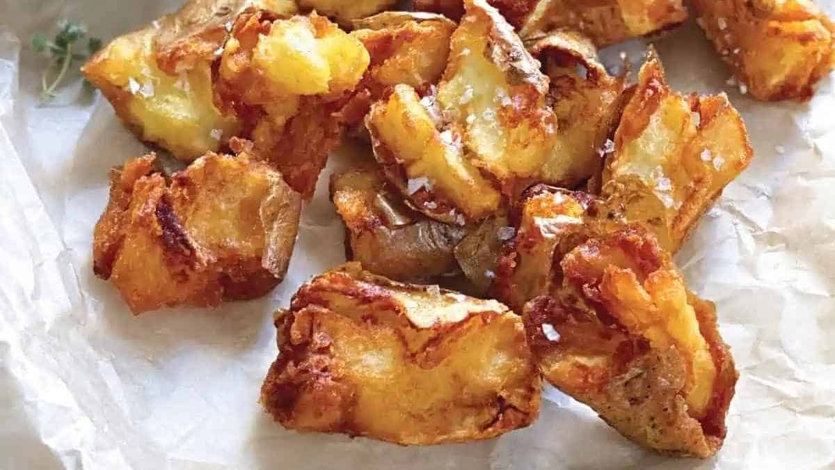 Fried potato wedges on a piece of paper.