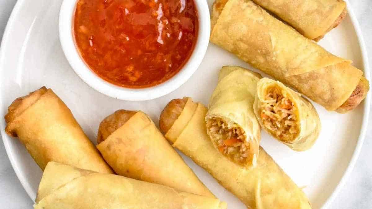 Thai spring rolls on a plate with dipping sauce.