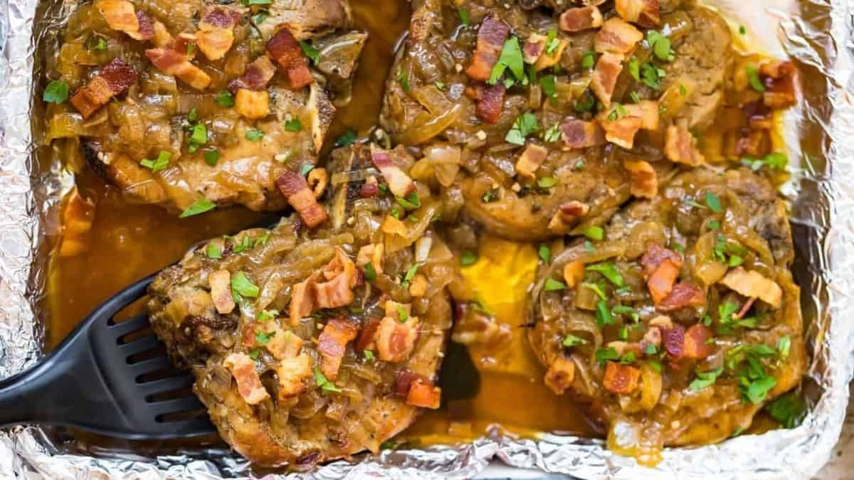 Pork chops in foil with onions and bacon.