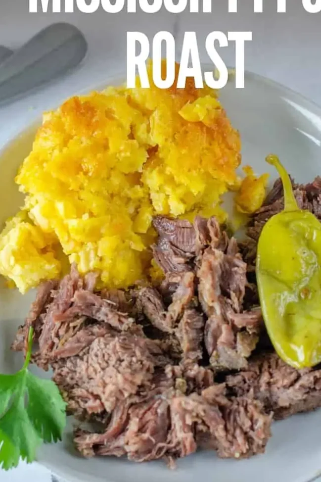 shredded mississippi roast on white plate with title text "Crockpot Mississippi Pot Roast."
