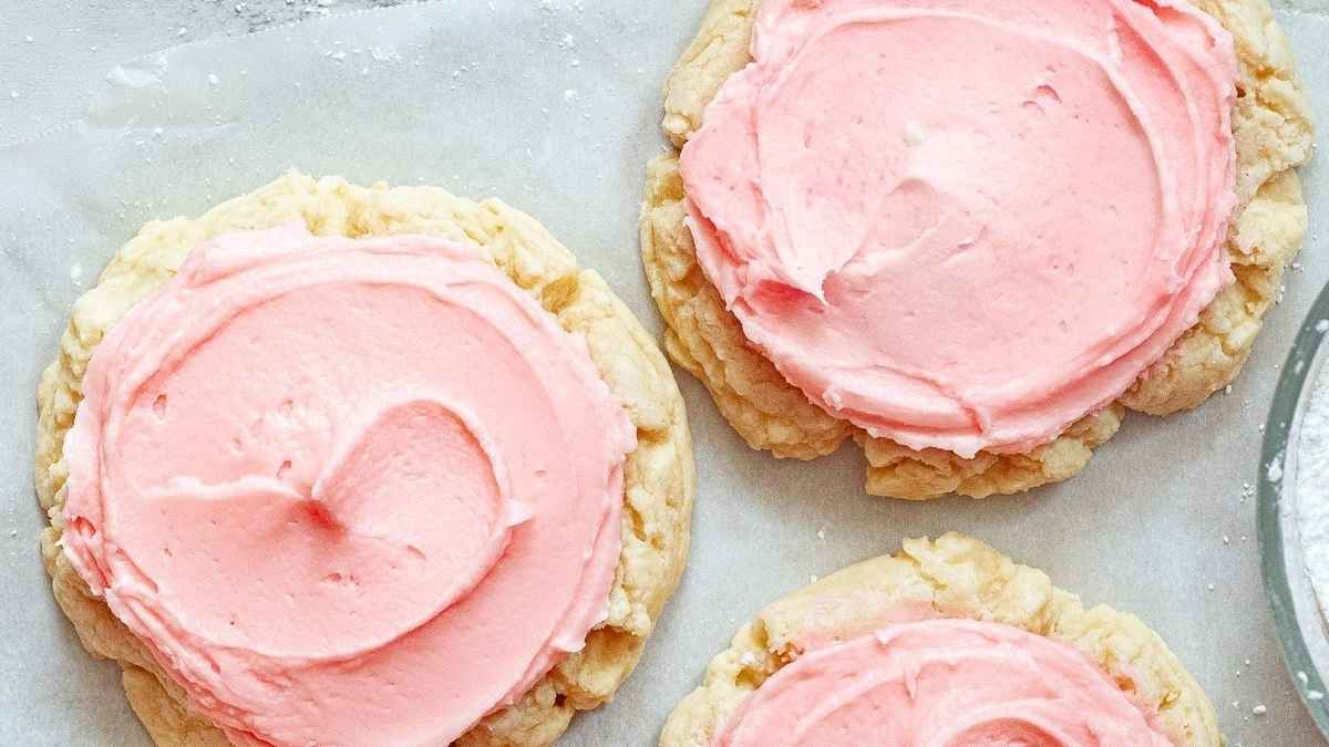 Pink frosted cookies on a baking sheet.