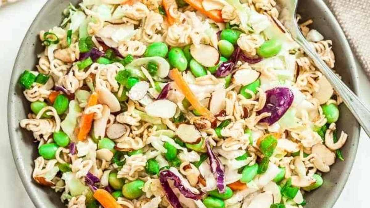 A bowl of asian noodle salad with a fork.