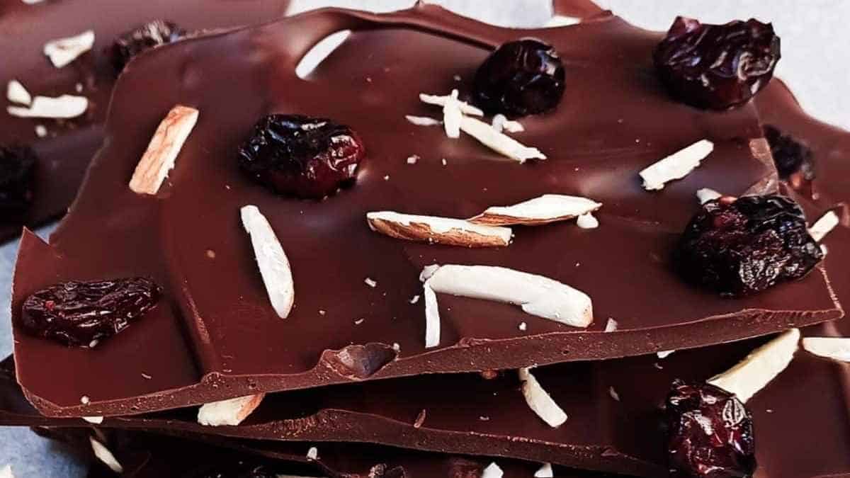 A pile of chocolate covered with cherries and almonds.