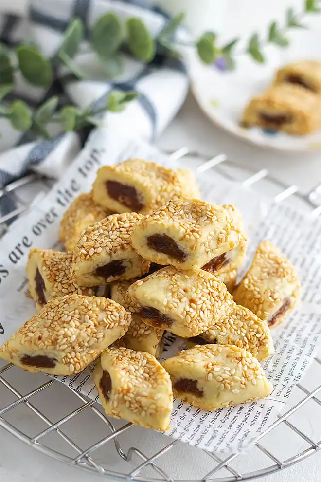 A tray of cookies with unique cookie recipes and sesame seeds on it.