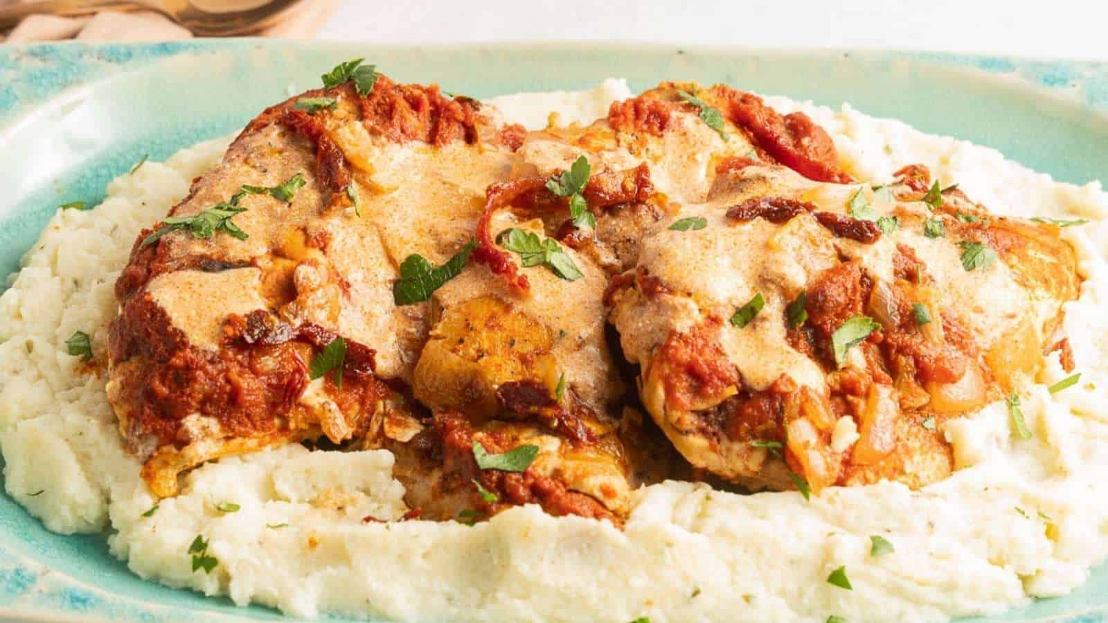 A plate with chicken and mashed potatoes on it.