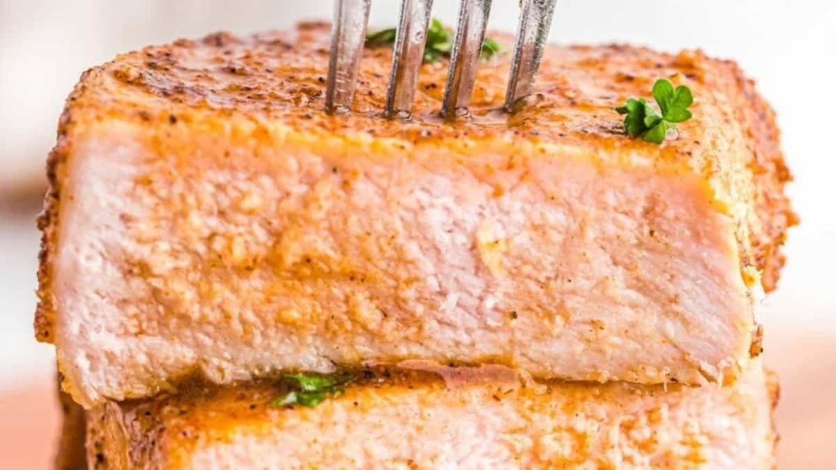 A stack of pork chops with a fork on top.