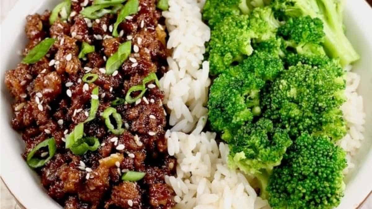A bowl of rice with beef and broccoli.