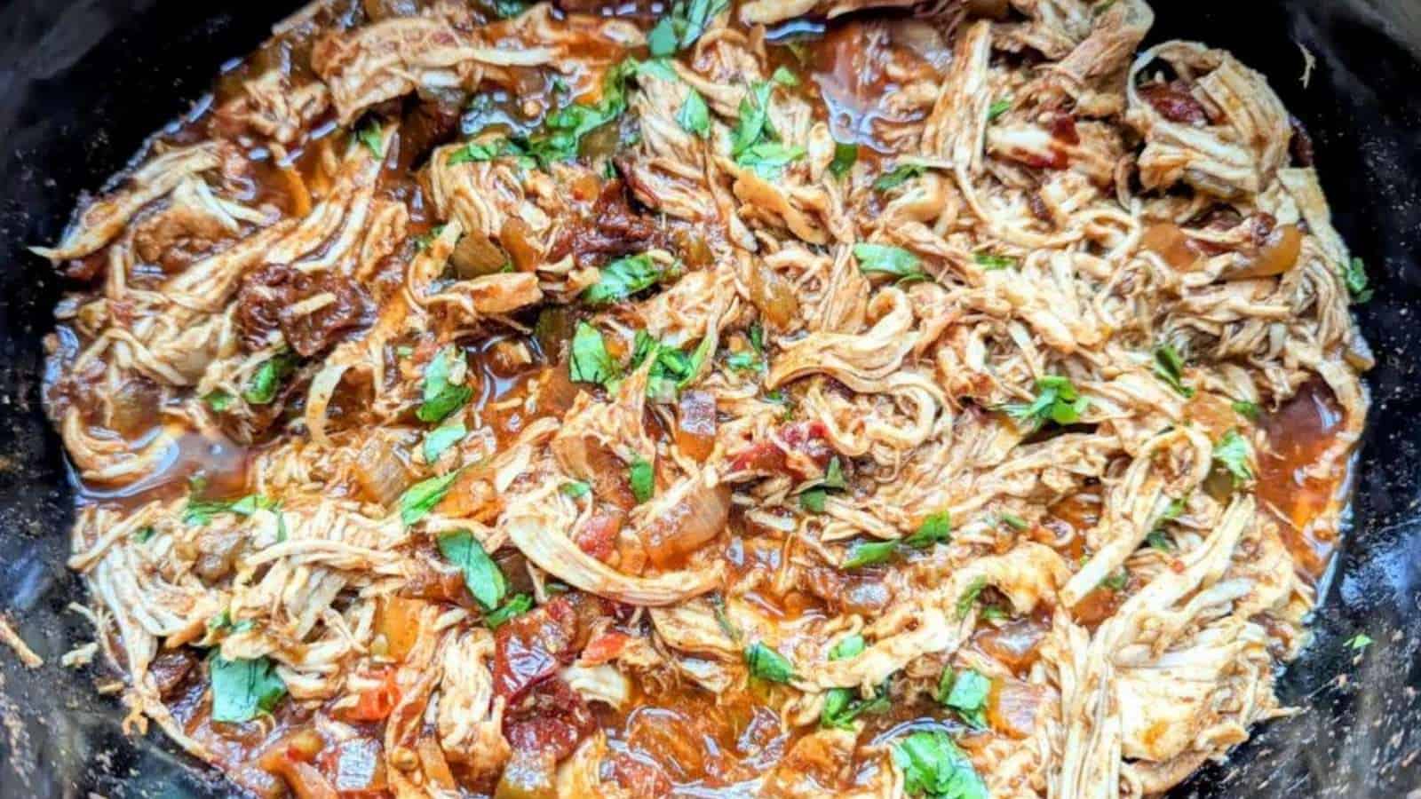 Shredded chicken in a slow cooker.