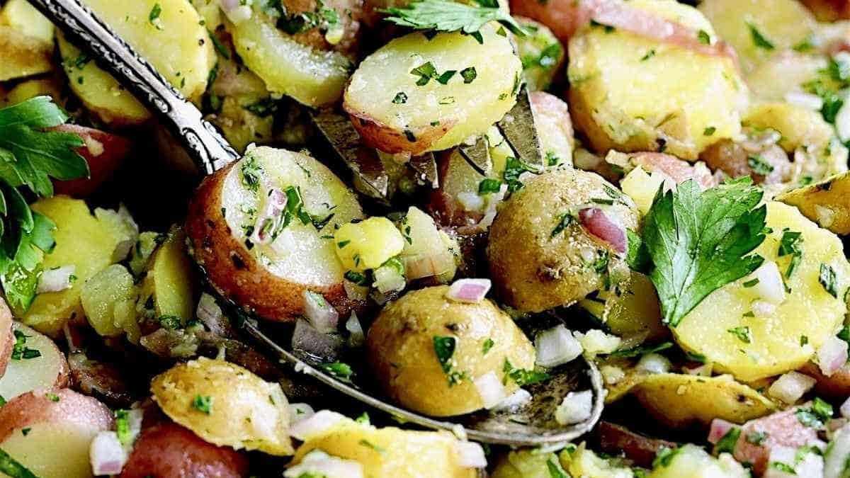 A bowl of potato salad with parsley and herbs.
