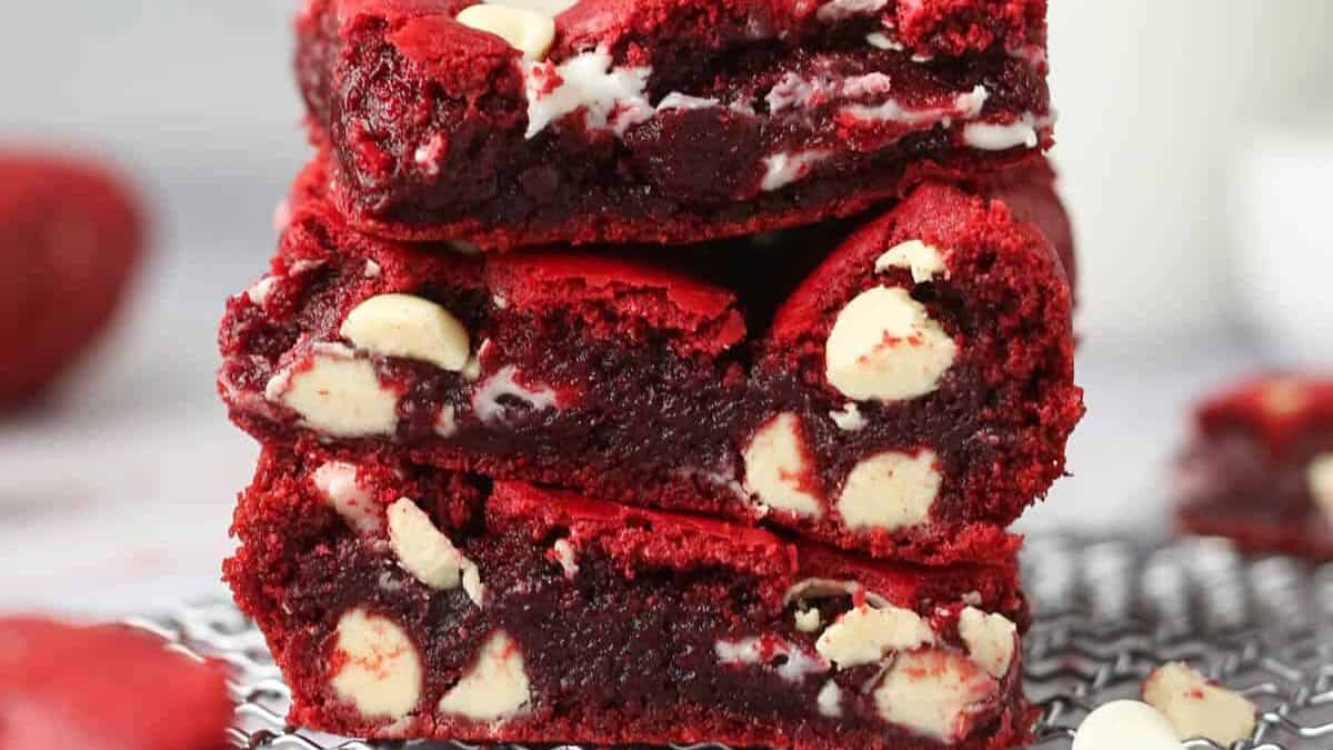 A stack of red velvet brownies on a cooling rack.