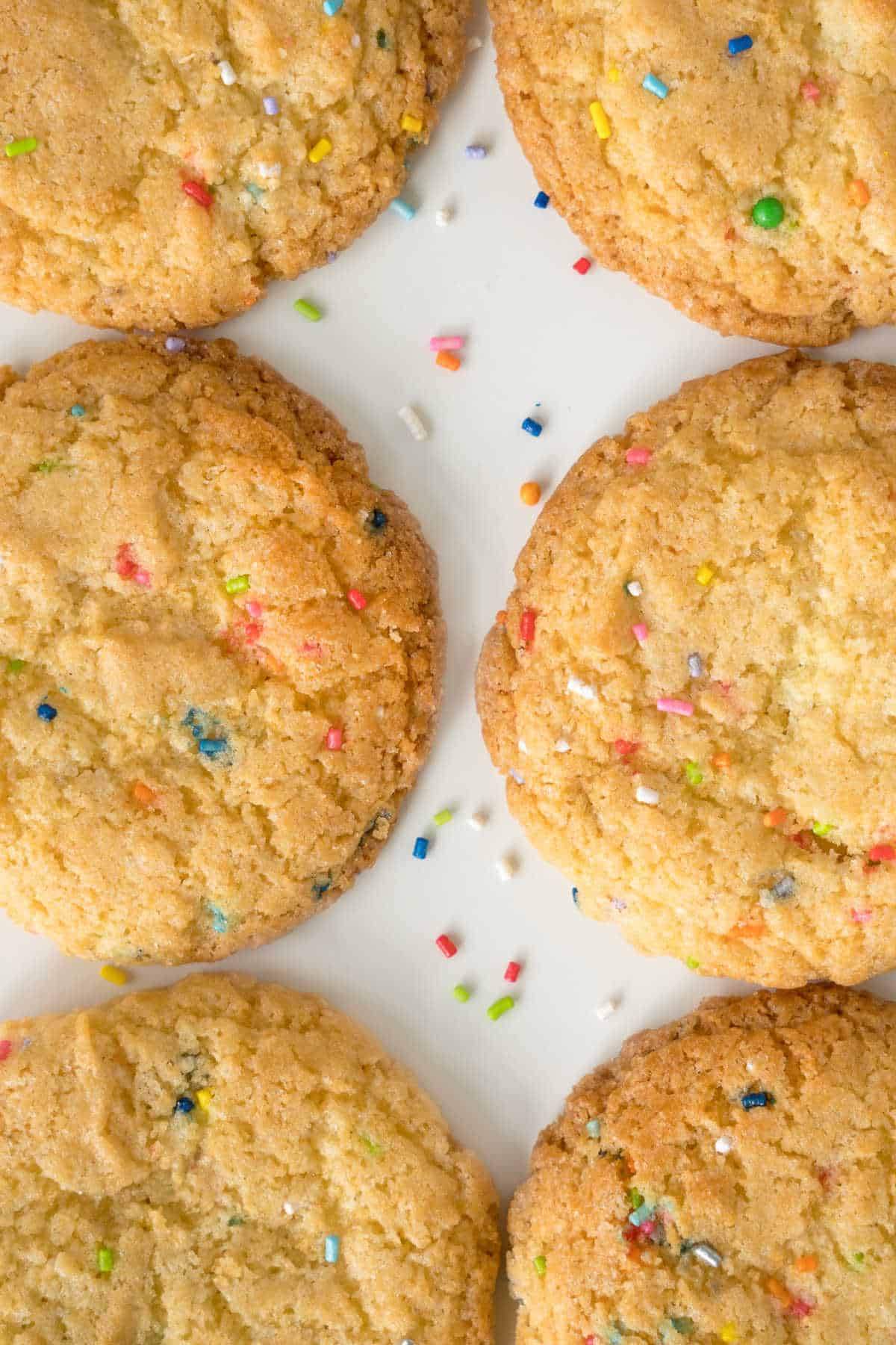 Unique sugar cookies with sprinkles on a white plate.