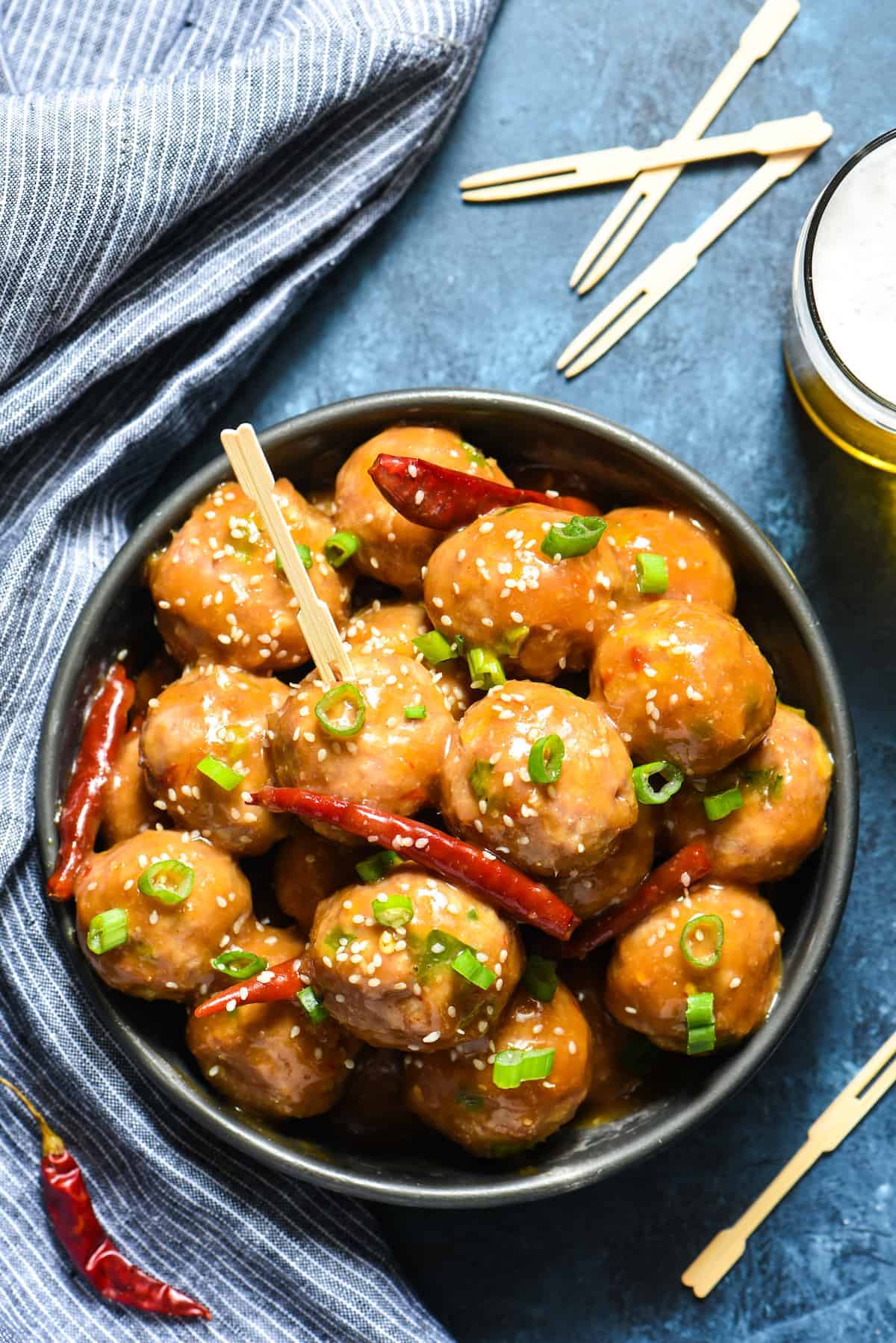 Chinese meatballs in a bowl on a blue background.