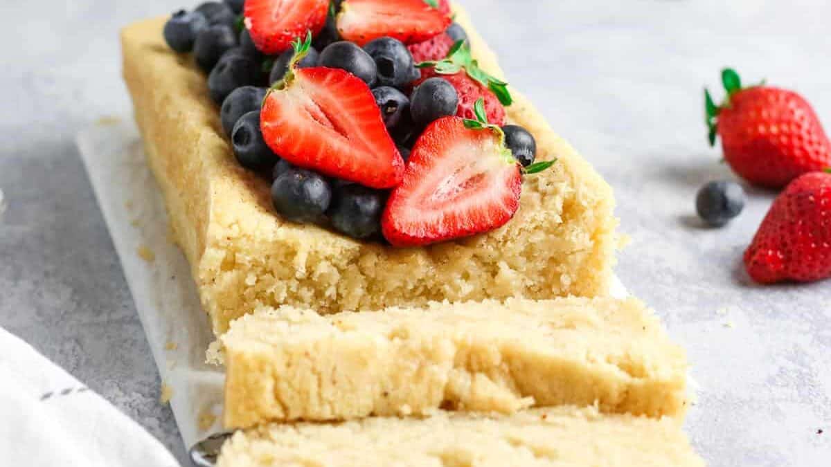 A slice of cake with berries and blueberries.