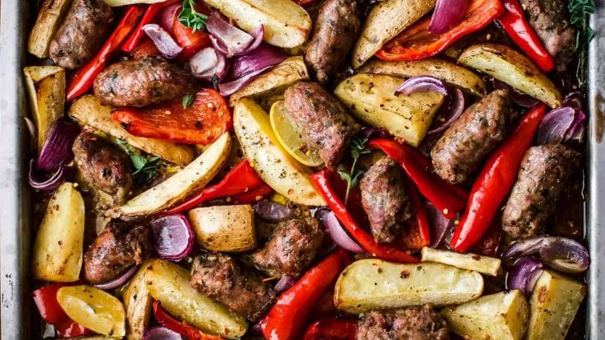 Roasted potatoes and sausages in a baking dish.