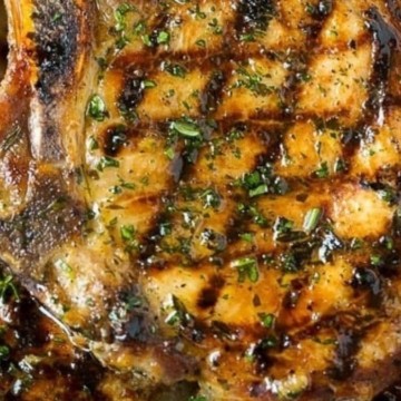 Grilled pork chops on a white plate.