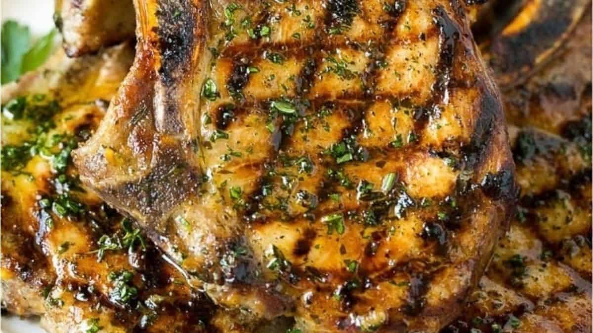 Grilled pork chops on a white plate.