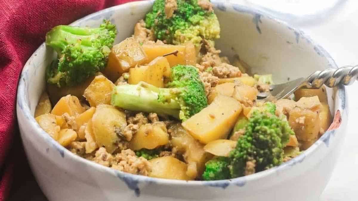 A bowl with broccoli and meat in it.