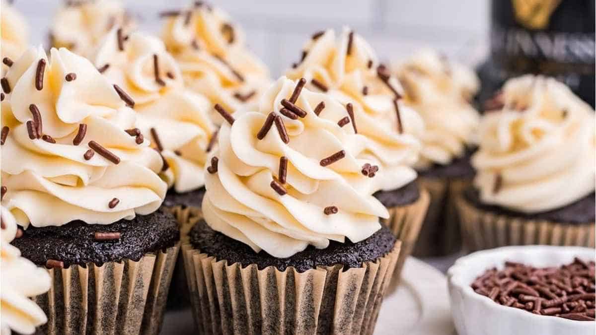 Guinness cupcakes with chocolate frosting and a bottle of guinness.