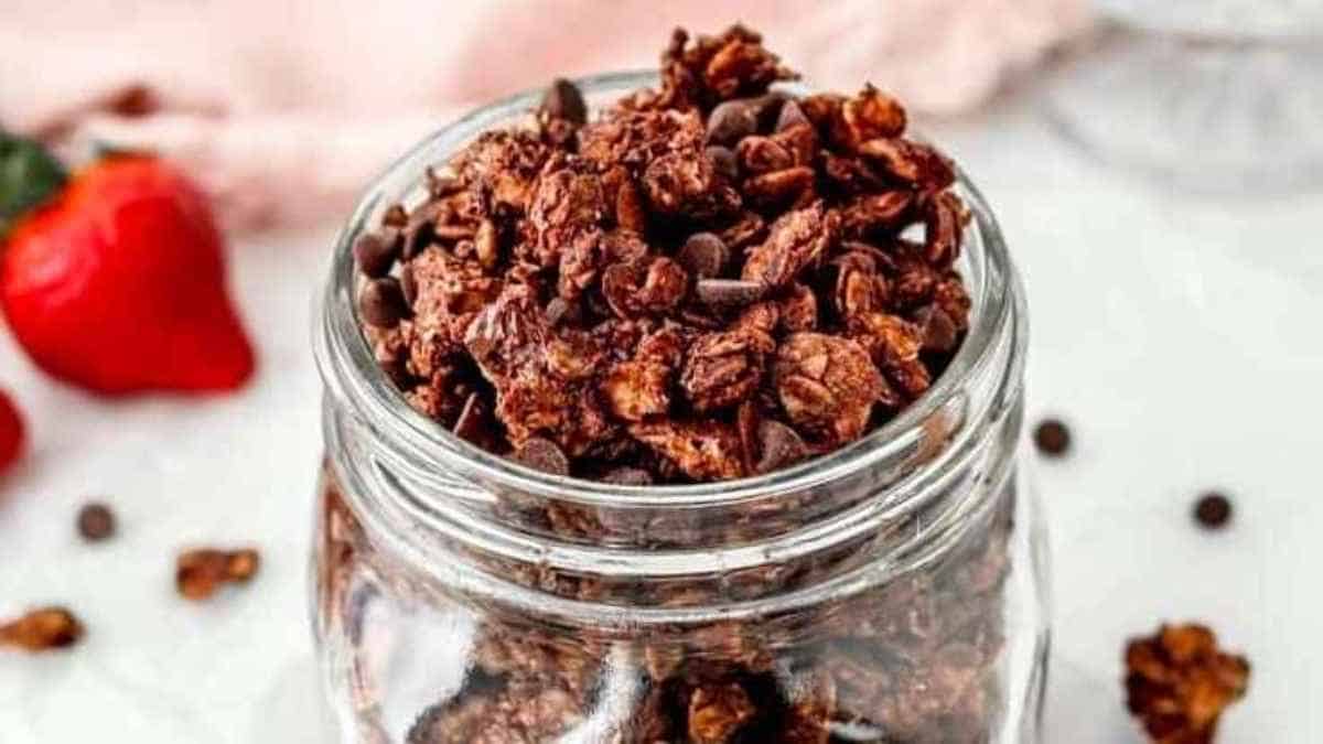 Chocolate granola in a jar with strawberries.