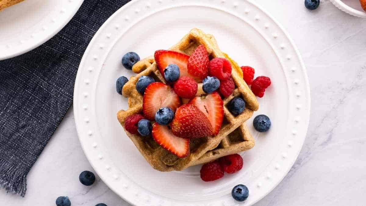 Waffles with berries and blueberries on a plate.