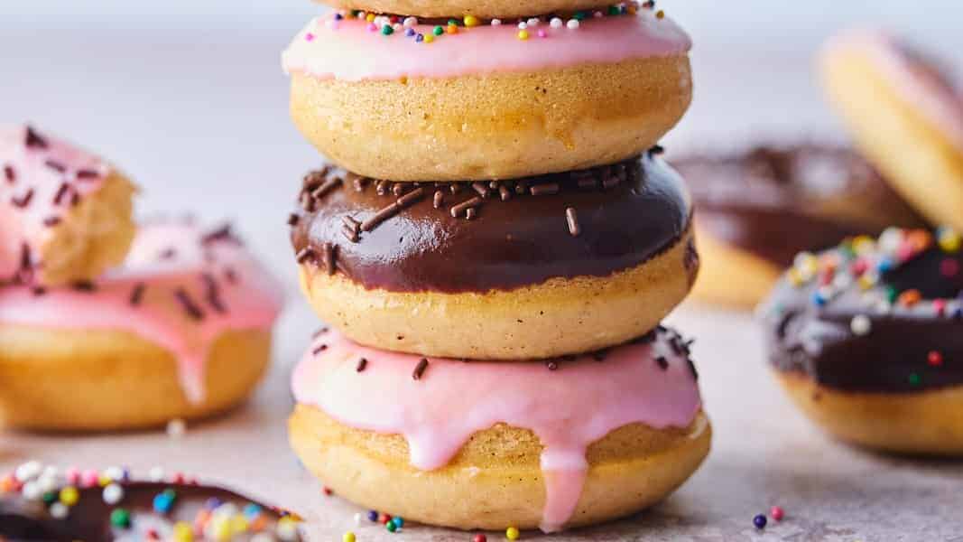 A stack of donuts with frosting and sprinkles.