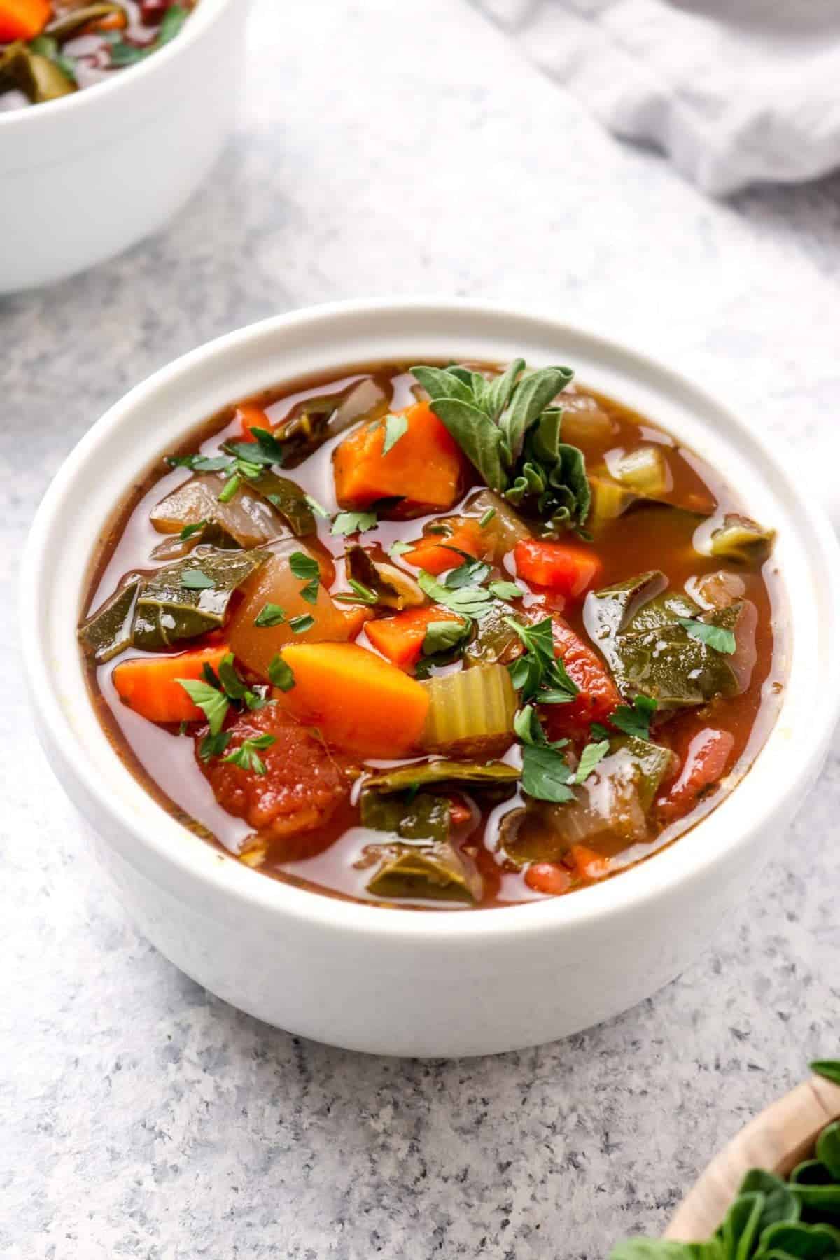 A closeup of Balsamic Vegetable Soup with greens and beans. 
