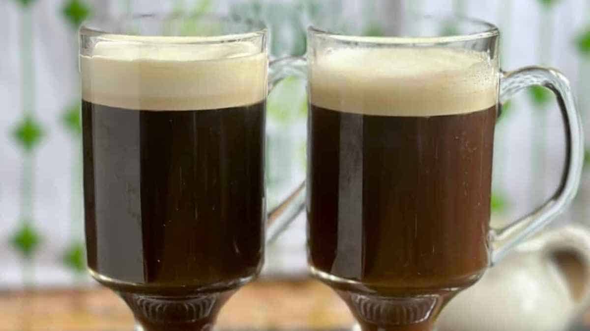 Two glasses of irish coffee on a table.
