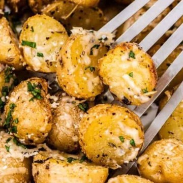Parmesan roasted potatoes in a baking dish with a fork.