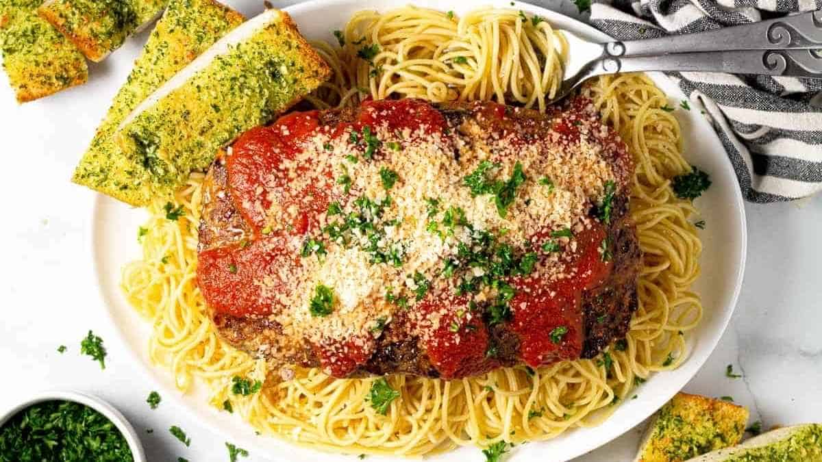 A plate of spaghetti and meatloaf.