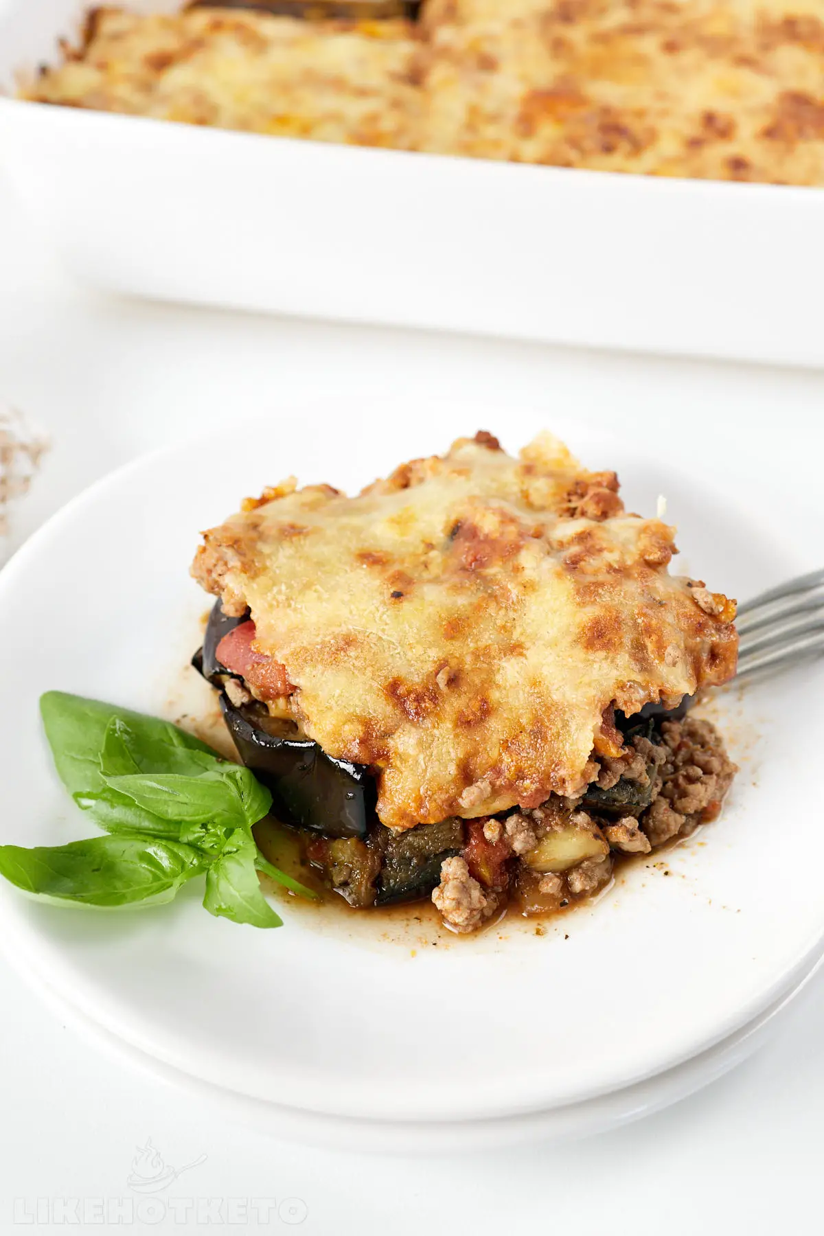 A serving of eggplant casserole with melted cheese topping. 
