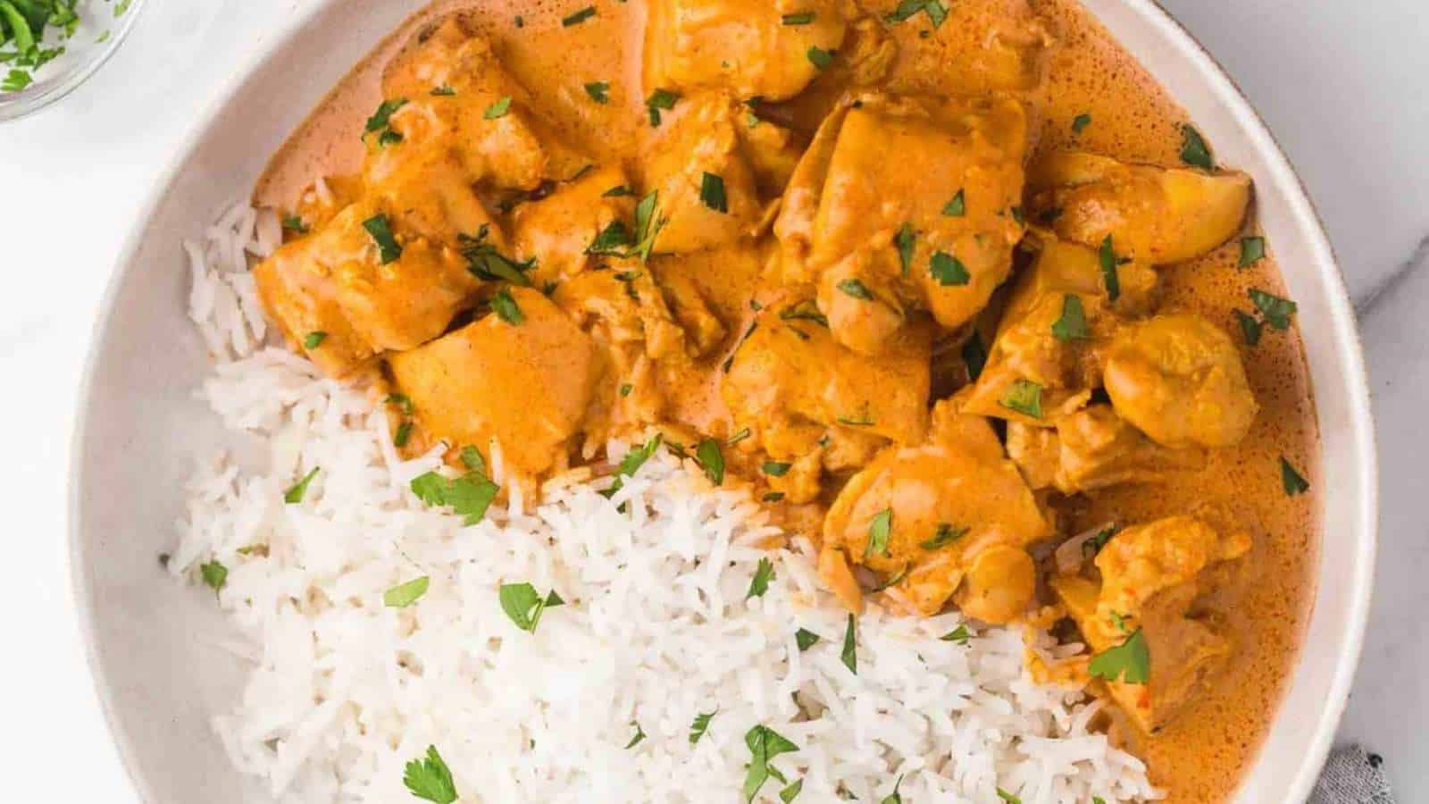 Chicken tikka masala in a white bowl with rice.