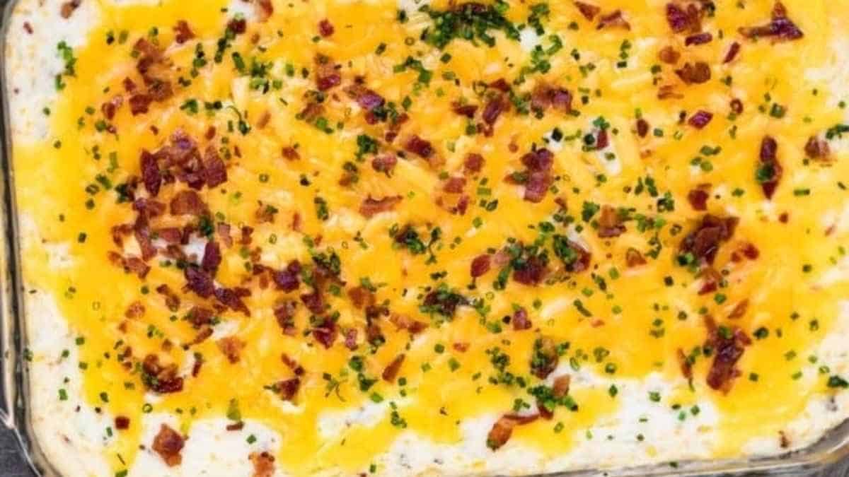 A casserole dish topped with cheese and bacon.