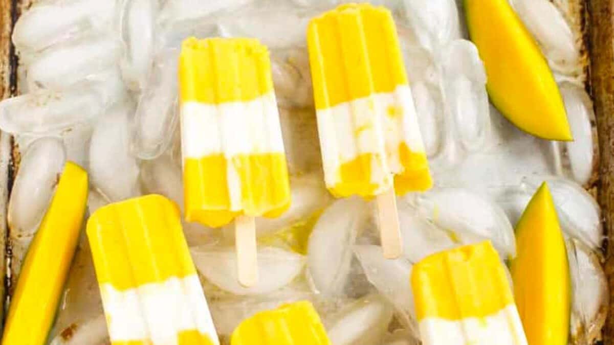 A tray of mango popsicles on ice.