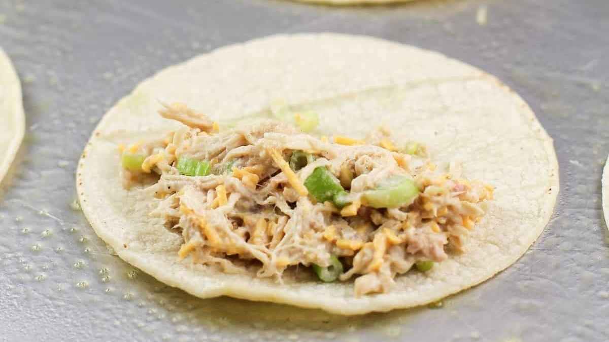 Chicken tacos on a baking sheet.
