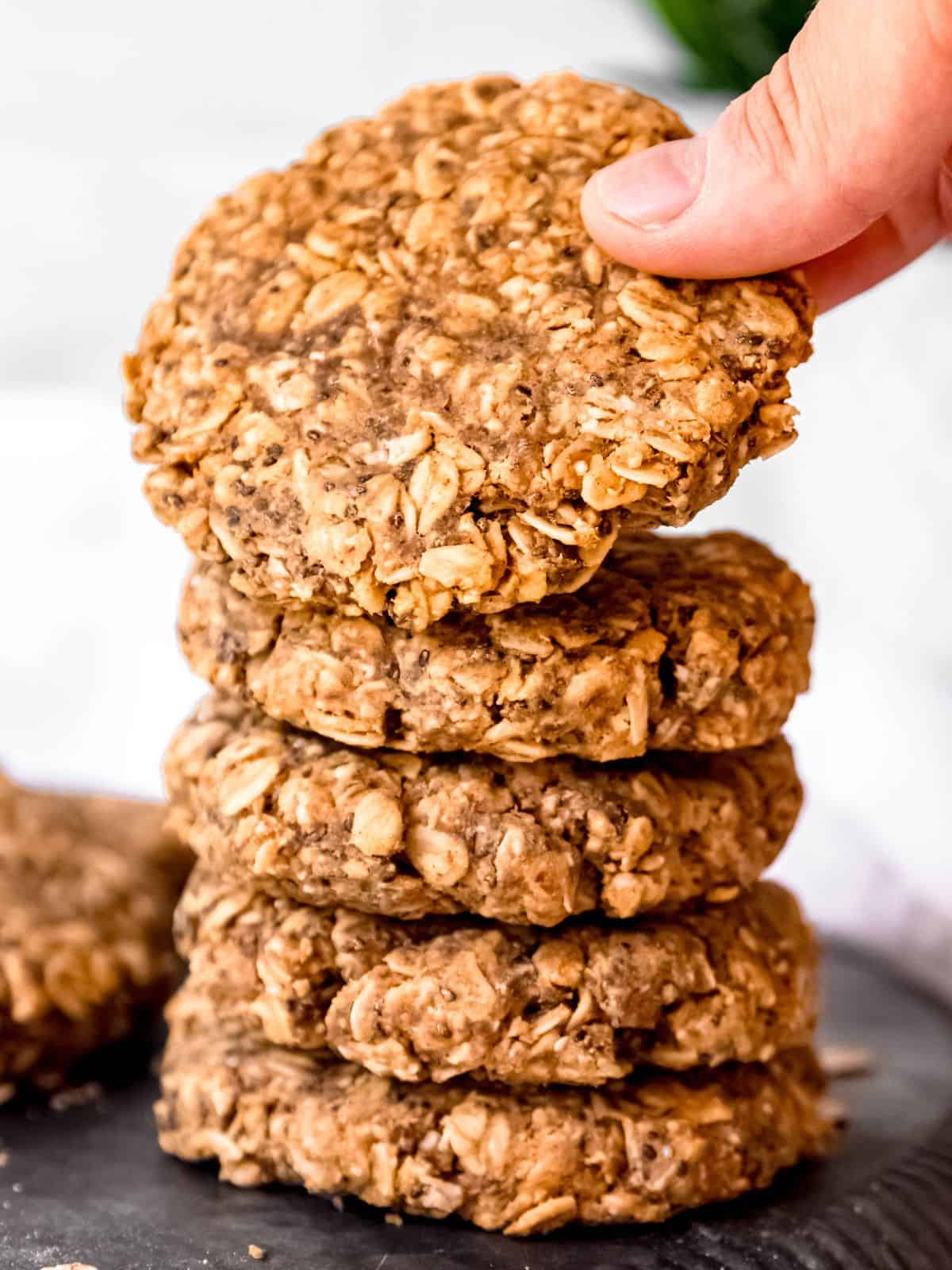 hand removing the top breakfast protein cookie in a stack of 5. 
